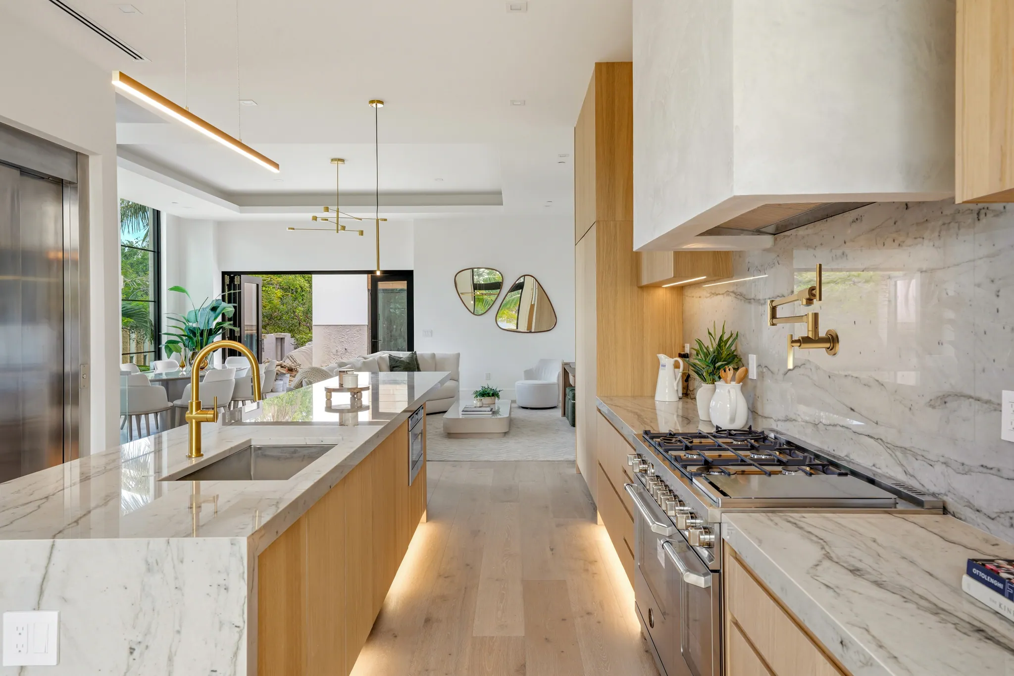 Galley kitchen with marble island, gas range, and view through to living room