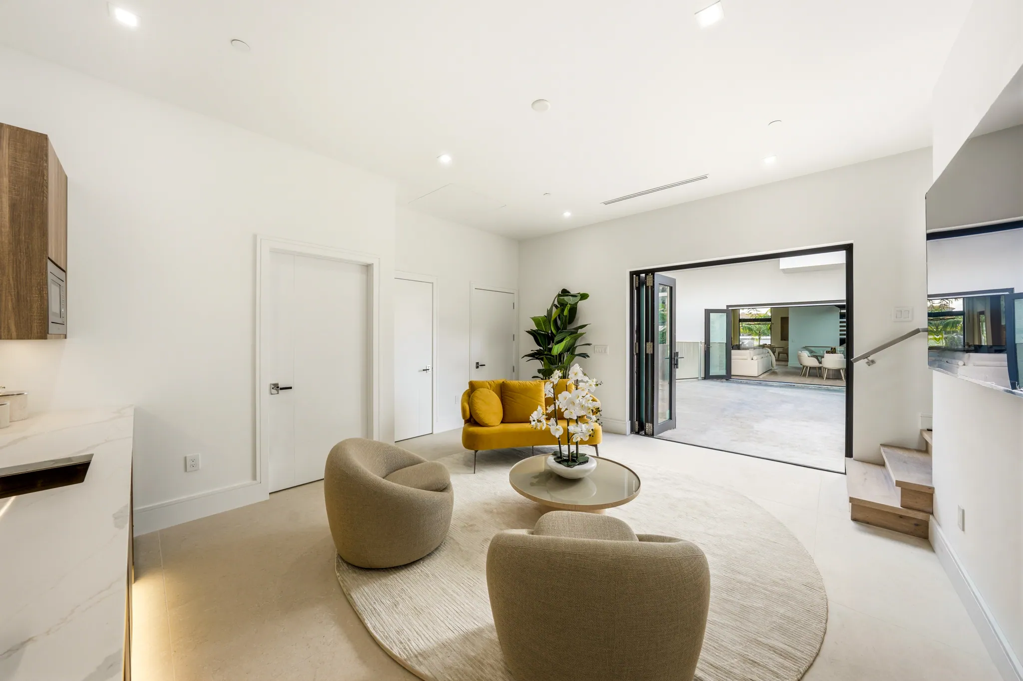 Guest house sitting room opening through bifold doors to courtyard terrace