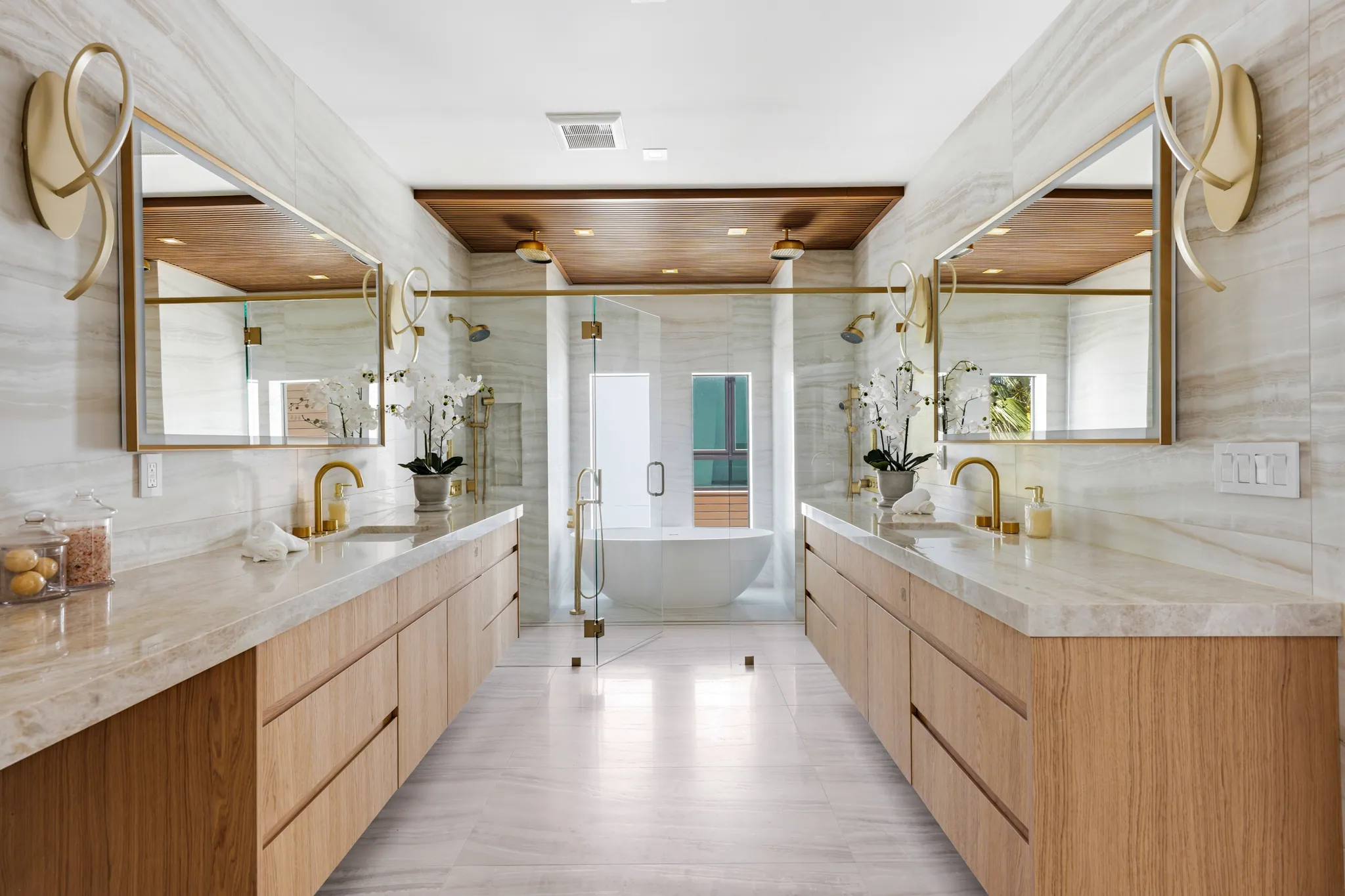 Primary bath with dual stone vanities, freestanding tub, and wood-paneled ceiling