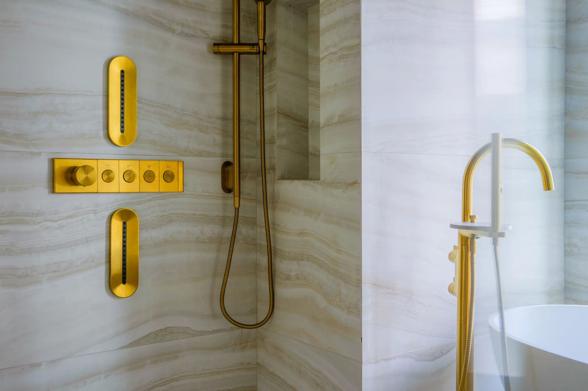 Detail of brass body sprays and shower controls in primary bath